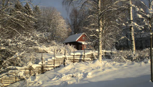 Bild på liten stuga och mycket snö